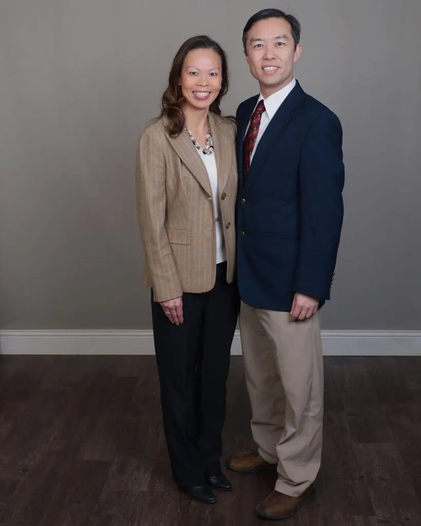 Smiling couple posing in formal attire.
