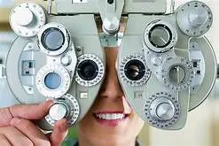 Optometrist performing eye exam with phoropter.