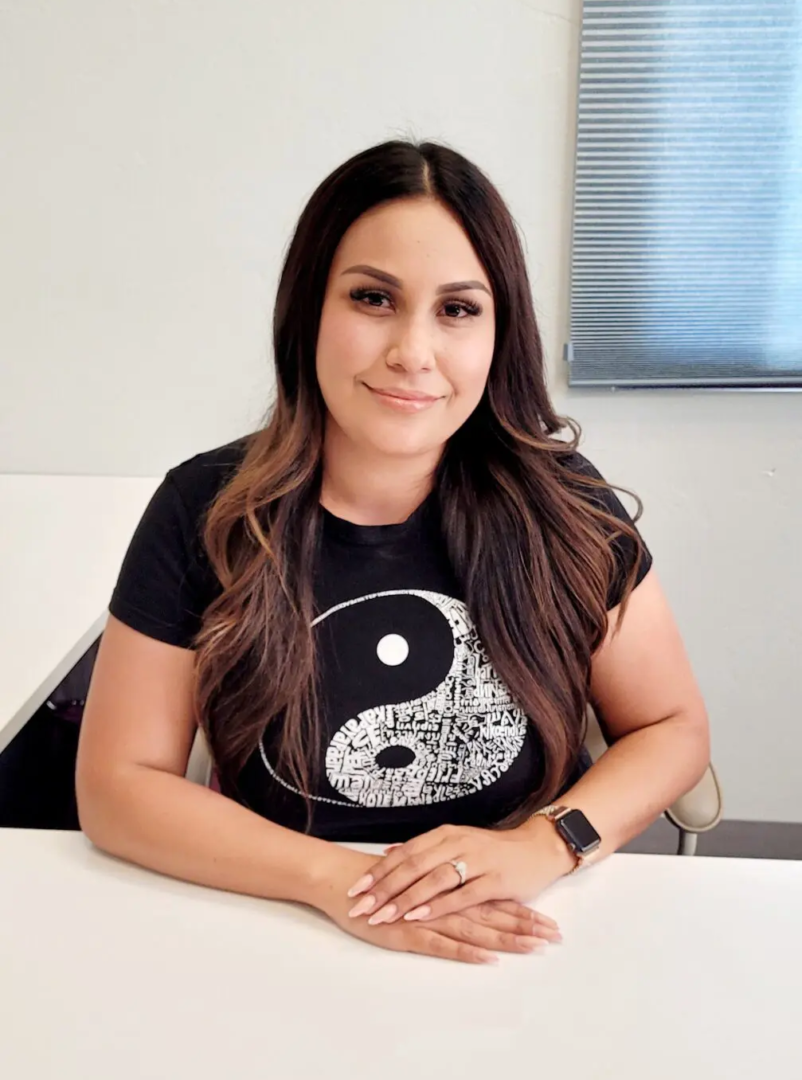 Person sitting at a desk, smiling calmly.