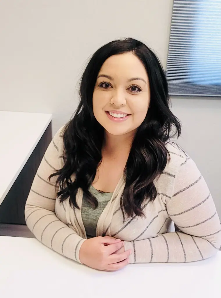Smiling woman sitting at a desk.