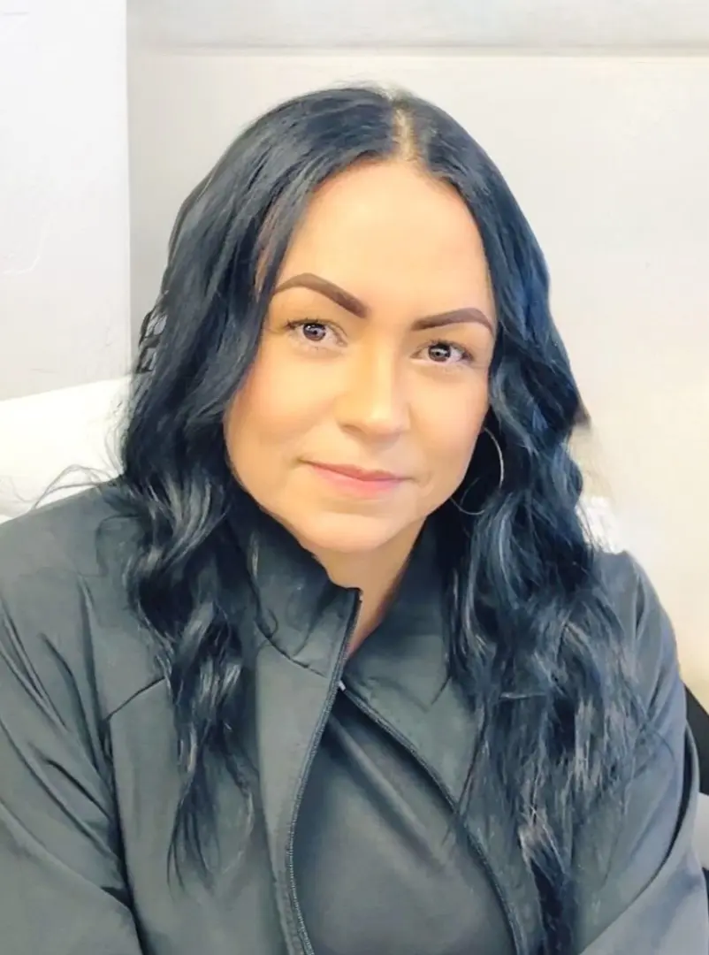 Woman with long dark hair, wearing jacket.