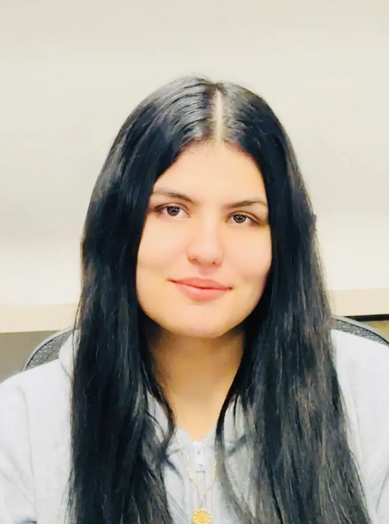 Woman with long black hair smiling.