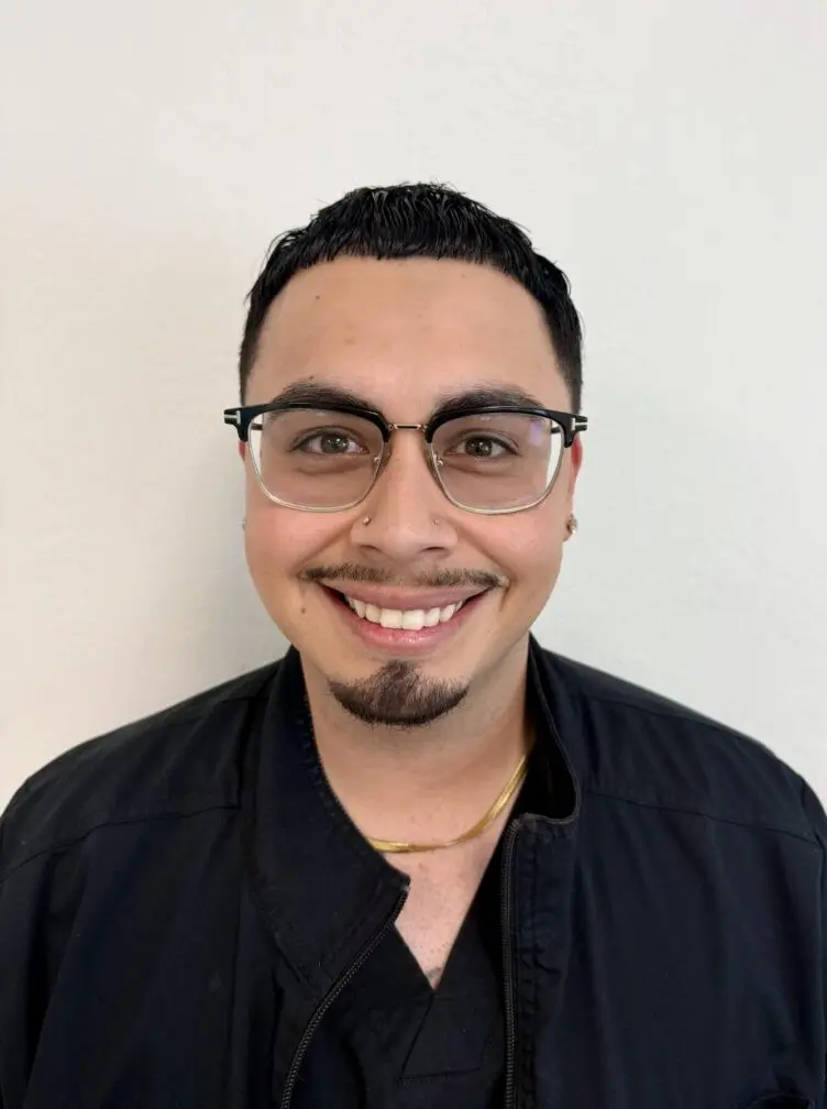 Smiling man wearing glasses and a jacket.
